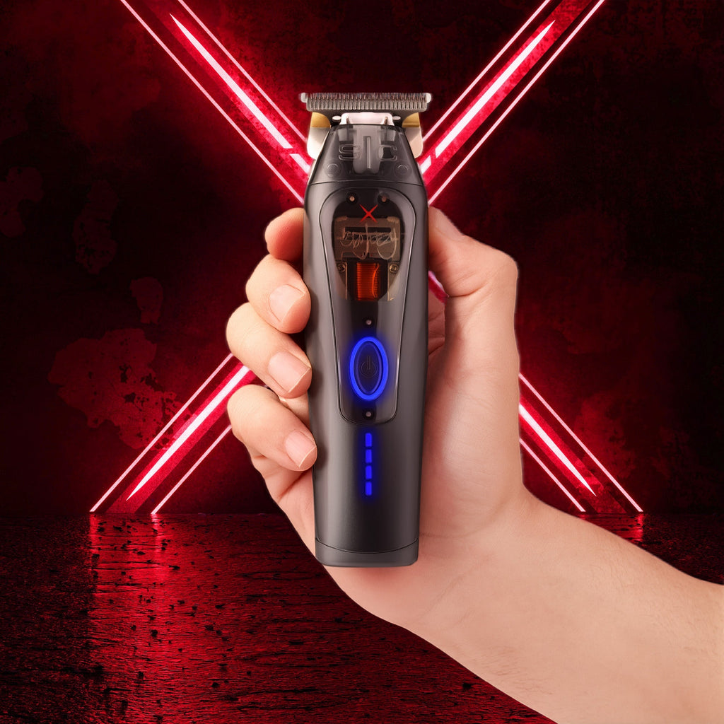 Hand holding black cordless hair trimmer, blue power light, gold blade